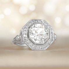 an engagement ring with a large diamond surrounded by smaller diamonds on the side and in the center