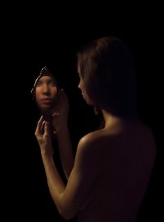 a woman is looking at her reflection in the mirror