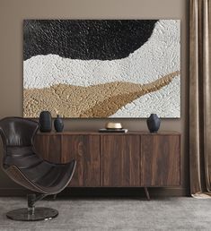 an abstract painting hangs on the wall above a modern sideboard