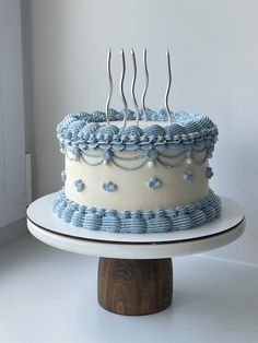 a blue and white cake with forks on top