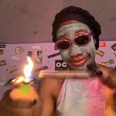 a person with a face mask holding a lit candle