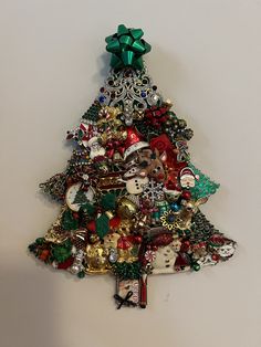 a christmas tree ornament hanging on the wall with ornaments all over it's base