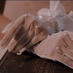 a pair of white gloves sitting on top of a book