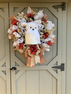 a wreath with an animal on it hanging from the side of a door