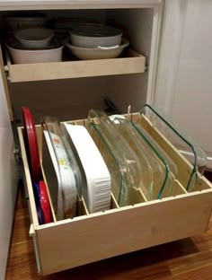 an open drawer with dishes in it