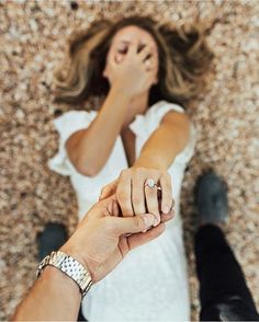 two people holding hands while standing next to each other on a carpeted floor with their arms in the air