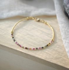 "Natural Multi-Color Tourmaline Bracelet Add color to your style with our tourmaline bracelet that's handmade in a spectrum of colors! Tourmaline is believed to promote inspiration and happiness, reduce fear, and build self-confidence. It is also a birthstone for October. It comes in many colors including pink, black, green, and yellow. This tiny bracelet is handmade with faceted, natural Tourmaline surrounded by permanently plated 24k gold or sterling silver glass beads. The clasp is sterling s Adjustable Tourmaline Beaded Bracelets With Gemstone Beads, Beaded Tourmaline Bracelets As A Gift, Multicolor Beaded Tourmaline Jewelry, Multicolor Tourmaline Beaded Jewelry, Beaded Tourmaline Bracelets With Round Beads, Pink Gemstone Beaded Bracelets For Jewelry Making, Adjustable Multicolor Gemstone Beaded Bracelets, Beaded Tourmaline Bracelets, Multicolor Faceted Tourmaline Beaded Jewelry