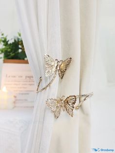 two gold butterflies are attached to the curtain