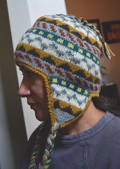 a woman wearing a multicolored knitted hat with braids on her head