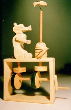 a wooden toy is sitting on top of a table and has wheels attached to it