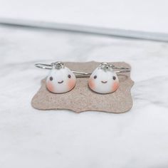 This is a listing for a pair of cute bao earrings! Just like the ones you would find at dim sum, these are the perfect accessory for any occasion. They come with stainless steel earring hooks! Stainless steel bao studs are available in my shop here: https://www.etsy.com/listing/1247789886/dim-sum-earrings-pork-bun-bao-polymer?click_key=fad7ad160f2d0a2d64eefee454163d2700e03eb6%3A1247789886&click_sum=0515cdf2&ref=shop_home_active_2 ♡ D I M E N S I O N S ♡ ❤ ~0.4 in. Length x ~0.4 in. wide ♡ C A R E ♡ ❤ Our charms are all handmade and should be handled with care ❤ This is NOT a toy and should not be given to young children ❤ Please also note that due to monitor differences, actual colors may vary  ❤ Made to order, actual item may vary  ♡ S H I P P I N G ♡  ❤ All packages will be shipped in a Nickel Free Novelty Earrings For Everyday Wear, Cute Everyday Earrings For Pierced Ears, Silver Hypoallergenic Kawaii Earrings, Hypoallergenic Silver Kawaii Earrings, Novelty Hypoallergenic Earrings For Everyday, Cute White Earrings For Everyday Wear, Cute Everyday Nickel-free Earrings, Kawaii Hypoallergenic Drop Earrings, Cute Everyday Dangle Earrings