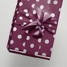 a gift wrapped in purple and white polka dot paper