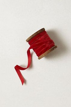 a spool of red thread on a white surface