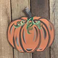 a painted pumpkin sitting on top of a wooden fence