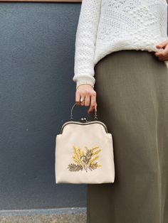 👜 Feel the Spirit of Time with this Mimosa Embroidered Bag 🌟 Elevate your style with this elegant embroidered bag inspired by nature. This handbag combines sophistication with practicality, making it an essential accessory for any occasion. 🌿 Handcrafted Perfection: Meticulously crafted with a single layer of rayon threads with attention to detail, this bag has impeccable quality and craftsmanship. 🌟 Stylish and Versatile: Subtle yellow mimosa embroidery adds elegance to the chic beige fabri Embroidered Top Handle Bag For Daily Use, Ladies' Floral Embroidery Top Handle Bag, Top Handle Bags With Floral Embroidery For Everyday, Embroidered Beige Tote Bag, Everyday Top Handle Bag With Floral Embroidery, Floral Embroidery Top Handle Bag For Everyday Use, Floral Embroidery Top Handle Shoulder Bag, Beige Embroidered Tote Bag, Embroidered Beige Satchel For Everyday Use