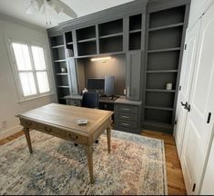 an office with built in bookcases and a desk