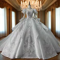 a white wedding dress on display in front of a chandelier