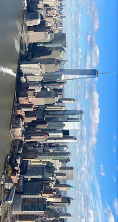 an aerial view of the city skyline with tall buildings and clouds in the blue sky