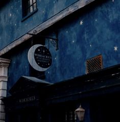 a blue building with a clock on the side and stars in the sky above it