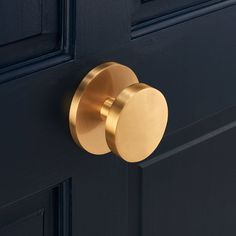 a close up of a door handle on a black door with gold trim and round knobs