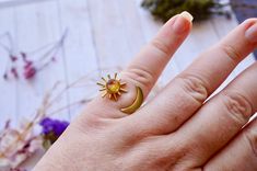 This adjustable ring is handmade with real pressed flowers encased in resin. Set in a beautiful metal gold frame on an adjustable raw brass band, this ring is like wearing a piece of nature. Head of ring measures about .7" x .7". Size 7 ADJUSTABLE to fit most fingers!Any questions, please feel free to contact us!✹ Custom orders available! Like what you see but don't love the colors or frame? Let us make something extra special just for you! Just send us a message and we will get back to you as s Adjustable Gold Ring With Magical Style, Celestial Style Metal Ring As Gift, Celestial Moon And Sun, Sun And Moon Rings, Customized Bridesmaid Gifts, Moon And Sun, Brass Band, Moon Ring, Resin Ring