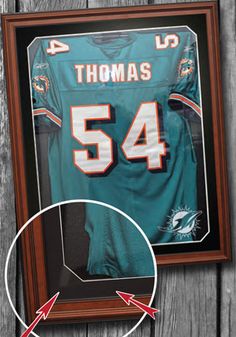 a framed football jersey with the number 54 on it and an arrow pointing towards it