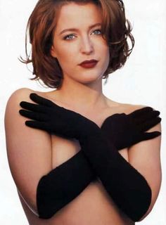 a woman wearing black gloves and posing for the camera