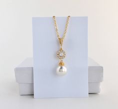 Classic pearl bridal necklace and pendant set with gold plated brass peg and bail. Necklace features a pendant with a 10mm Swarovski single pearl drop that dangles from round cubic zirconia halo connector and bail. Length of the gold plated chain is 18 inches and comes with 2 inches extender and lobster clasp. For matching earrings click: https://www.etsy.com/listing/577296408/gold-halo-pearl-bridal-earrings-gold?ref=listing-shop-header-1 For complete set click: https://www.etsy.com/listing/5772 Gold Teardrop Pendant Bridal Necklace As Gift, Gold Bridal Necklace With Pearl Drop For Bridesmaid Gift, Gold Pearl Drop Bridal Necklace For Bridesmaid Gift, Gold Pearl Drop Necklace For Bridesmaids, Bridesmaid Jewelry Gold, Bridal Necklace Gold, Gold Bridesmaid Jewelry, Gold Crystal Necklace, Schmuck Gold