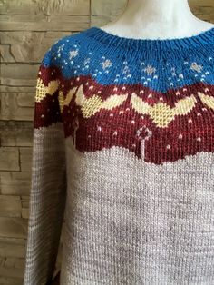 the sweater is knitted and has snowflakes on it