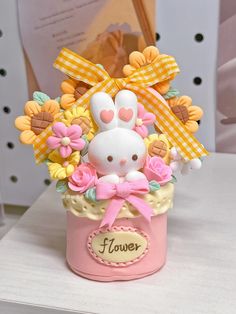 a pink vase filled with flowers and a white bunny in it's centerpiece