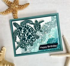 a happy birthday card with sea turtle and starfish on the table next to it