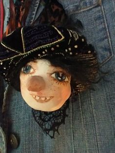 a doll wearing a black hat with lace on it's head and eyes is laying down