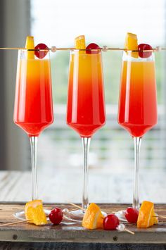 tequila sunrise mimosa cocktails with orange slices and cherries on the rim