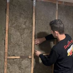 a man that is standing in front of a wall with some kind of insulation on it