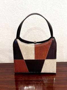 This vintage item is a Naturalizer patchwork style, simulated snakeskin leather handbag in neutral brown tones.  The purse has two dark brown top handles.  The frame, push clasp and four feet are brass.  The patchwork is on the front and a portion of the bottom of the purse.  The 1/2" wide handles extend to 6" above the clasp.  The clasp is 1/2"H and provides are very sturdy closure.  The interior is black cloth, zipper pocket, and Naturalizer label.  This handbag is in excellent condition.  The Retro Brown Square Shoulder Bag, Brown Square Satchel With Handles, Vintage Brown Square Bag, Retro Brown Satchel With Top Carry Handle, Vintage Square Satchel With Handles, Multicolor Rectangular Satchel For Formal Occasions, Formal Multicolor Rectangular Satchel, Dark Brown Top, Top Handle Bags