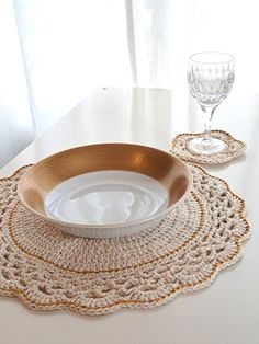 a crocheted placemat and plate on a white table