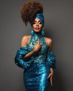 a woman in blue sequins posing for the camera with her hands on her hips