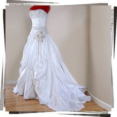 a wedding dress is displayed on a mannequin in a room with hardwood floors