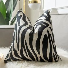 two black and white zebra print pillows on a fur rug