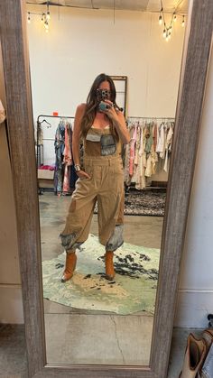 a woman taking a selfie in front of a mirror with shoes on the floor