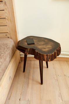 a wooden table sitting on top of a hard wood floor next to a bed in a room