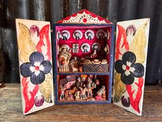 an open box with figurines in it on a wooden table