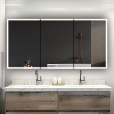 a bathroom vanity with two sinks and large mirrors above it, in front of a wall mounted mirror