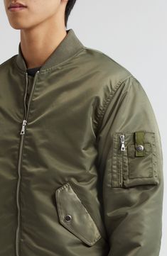 Classic detailing, such a sleeve utility pocket and ribbed trim, authenticates the military-inspired look of this bomber jacket crafted of nylon twill. 25 1/2" length (size Medium) Front zip closure Blade collar Ribbed cuffs and hem Front snap-flap pockets; sleeve utility pocket Lined 100% nylon Dry clean Imported Designer Clothing Green Streetwear Outerwear With Flap Pockets, Green Outerwear With Flap Pockets For Streetwear, Military Style Nylon Khaki Outerwear, Military Style Solid Color Nylon Outerwear, Military Style Nylon Outerwear, Solid Military Utility Jacket For Streetwear, Military Utility Jacket For Streetwear, Military Utility Jacket With Side Pockets For Streetwear, Pilot Style Outerwear For Fall Streetwear