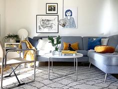 a living room filled with lots of furniture and pictures on the wall above it's coffee table