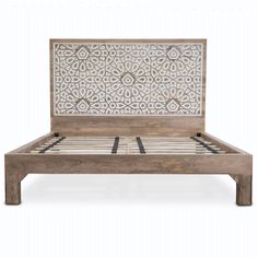 a wooden bed with an intricate design on the headboard