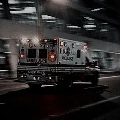 an ambulance is driving down the street at night