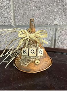 a small wooden bell with the word boo spelled out on it's front and side