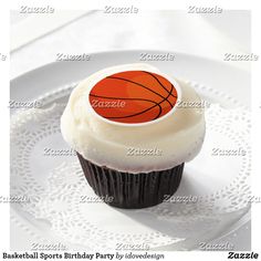 a cupcake with white frosting and an orange basketball on top is sitting on a plate