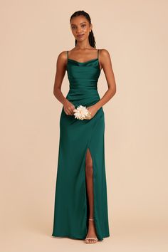 a woman in a long green dress with a slit down the side and one leg